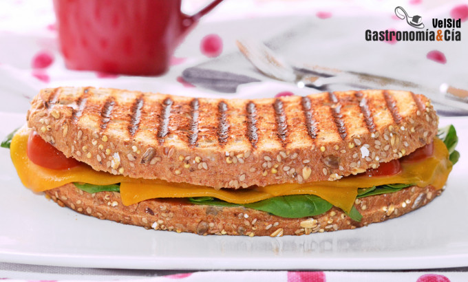 Bocadillo caliente de queso cheddar, espinacas y tomate