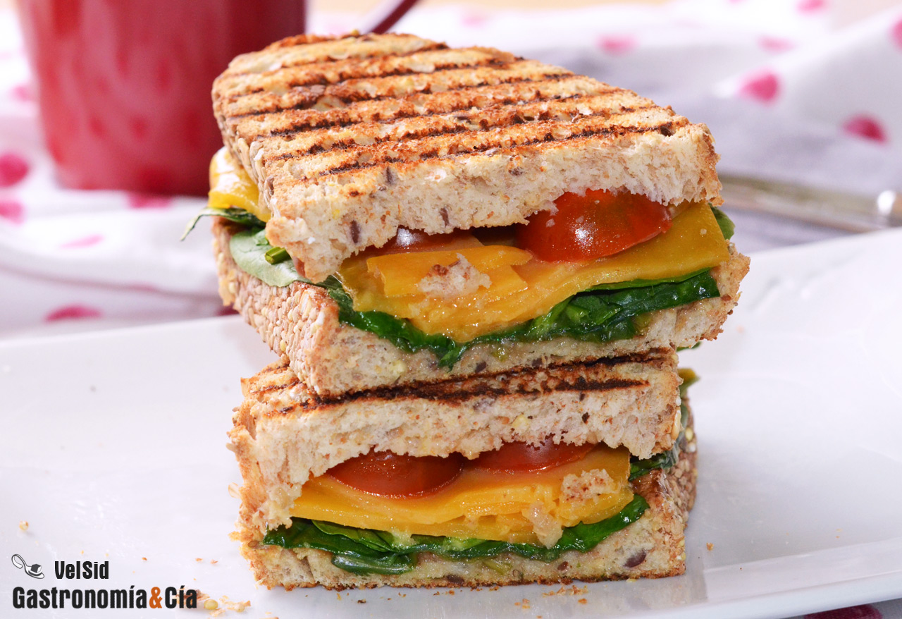 Bocadillo caliente de queso cheddar, espinacas y tomate