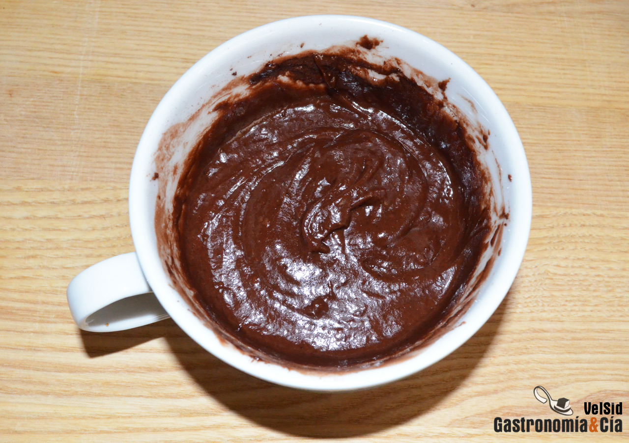 Bizcocho en taza de chocolate y cerezas