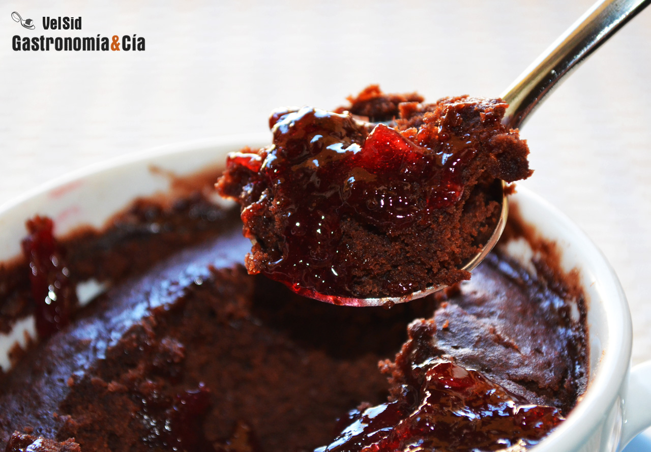 Bizcocho en taza de chocolate y cerezas