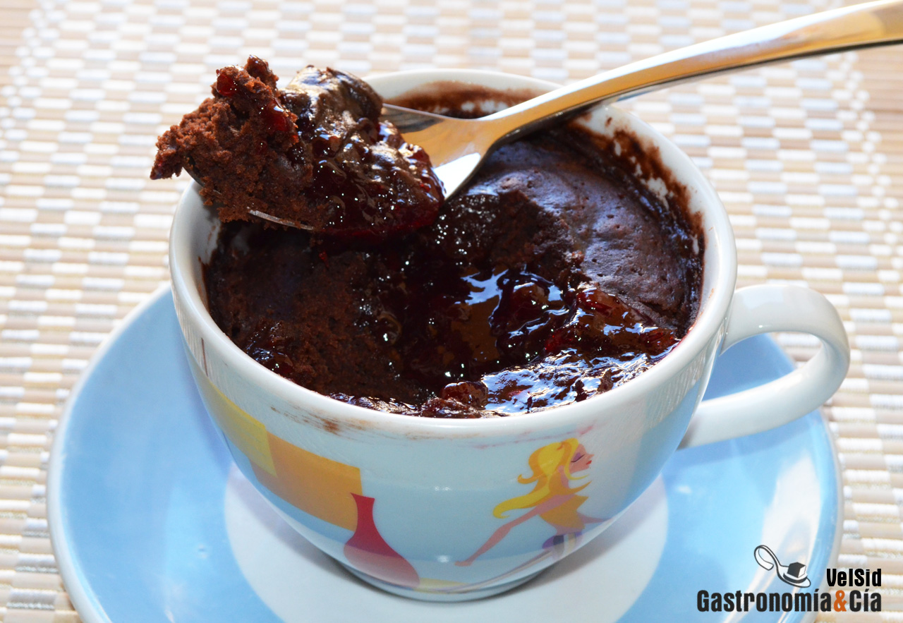 Bizcocho en taza de chocolate y cerezas