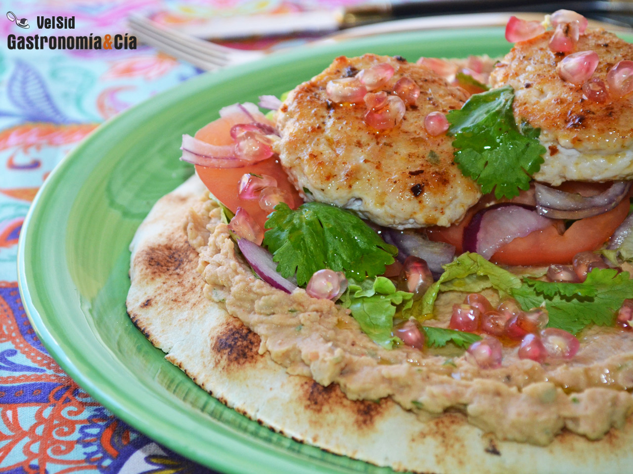 Pan pita con hummus de alubias, pollo especiado y grana