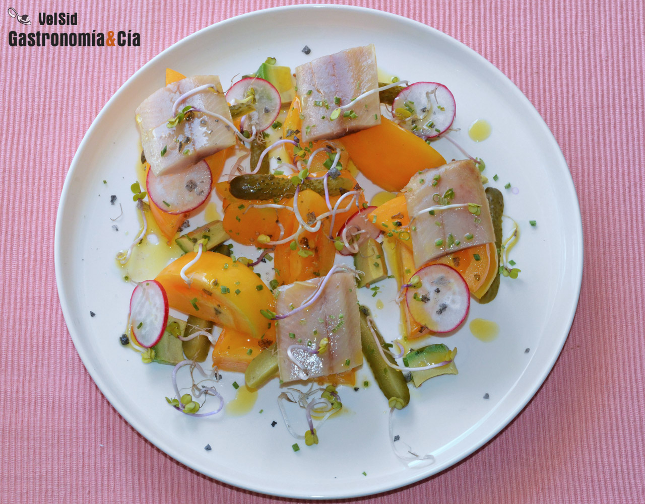 Ensalada de tomate amarillo con arenque ahumado y pepin