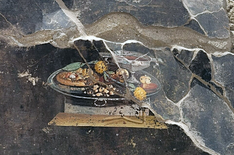 Representación de lo que parece una Pizza, hayada en una pared de una excavación arqueológica en Pompeya.