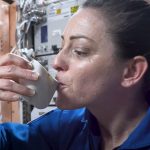 Beber en una taza de gravedad cero en el espacio