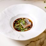 Merluza con guisantes y caldo de cebolla